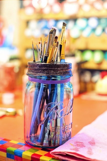 paint brushes in a jar against a colourful background Image by Jill Wellington from Pixabay