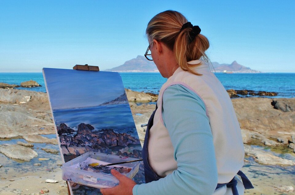 female artist painting a landscape