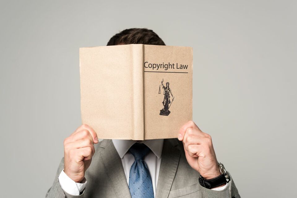 man holding copyright law book in front of his face